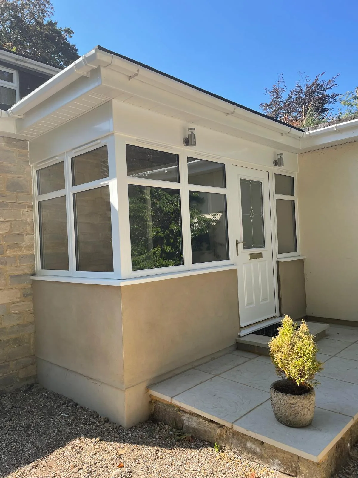 Completed porch extension with white uPVC windows and stone-effect walls